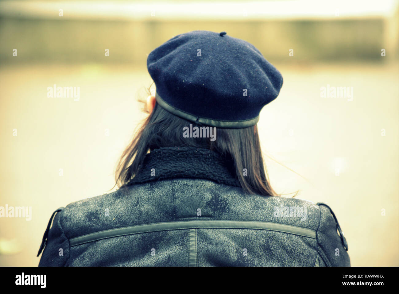 Ansicht der Rückseite des jungen Trendy modische Sitzendes Mädchen mit blauen Baskenmütze Kopf George Square Glasgow Stockfoto