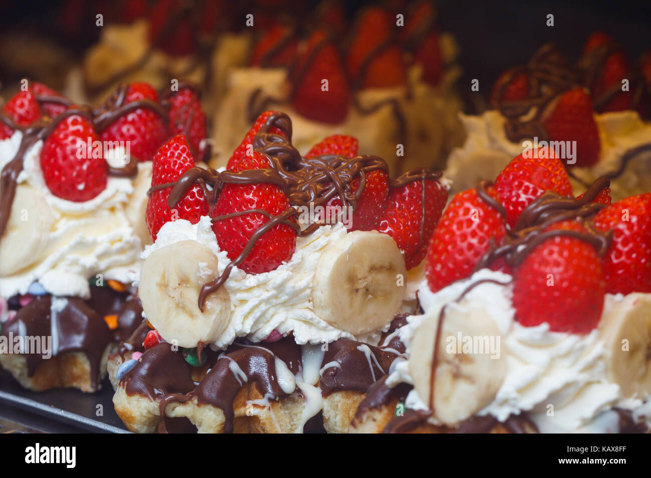 Belgische Waffeln mit Sahne, Schokolade und Erdbeeren auf dem Display Case Stockfoto