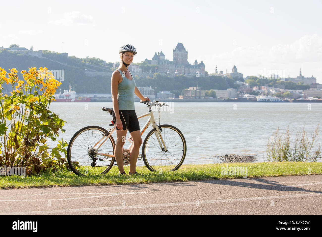 Junge Frau Reiten Fahrrad ausserhalb mit Quebec anzeigen Stockfoto