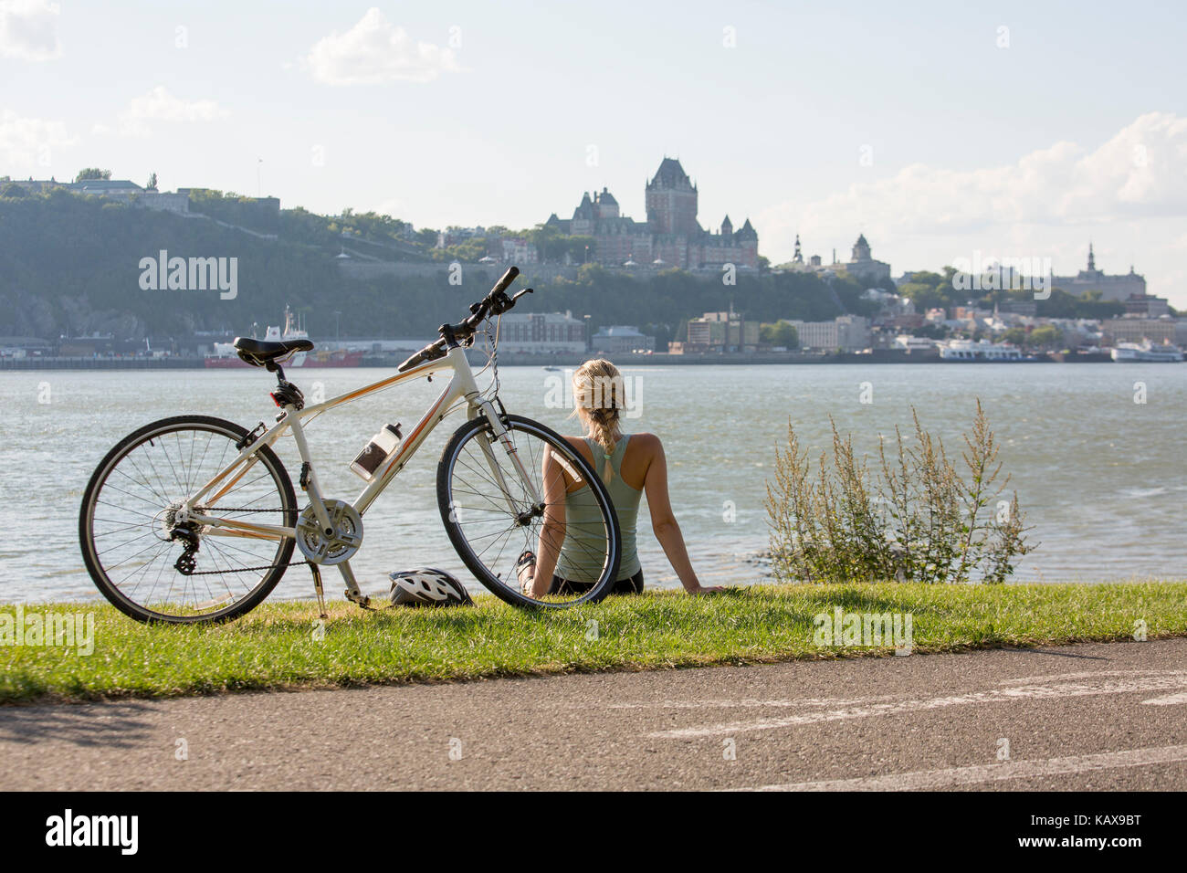 Junge Frau mit dem Fahrrad ausserhalb mit Quebec anzeigen Stockfoto
