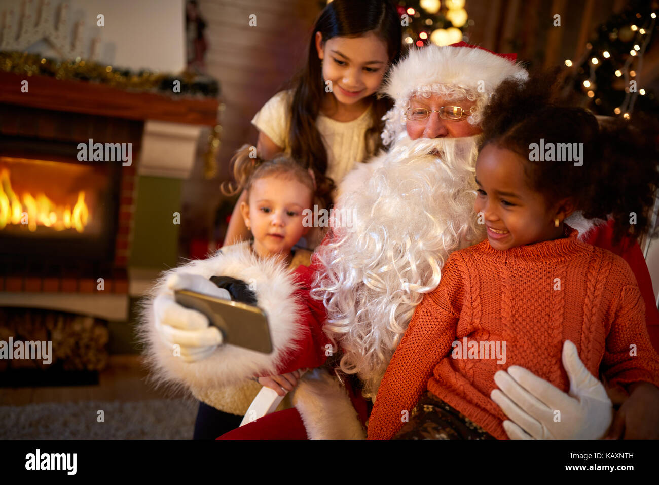 Santa claus Macht selfie mit drei netten Mädchen Stockfoto