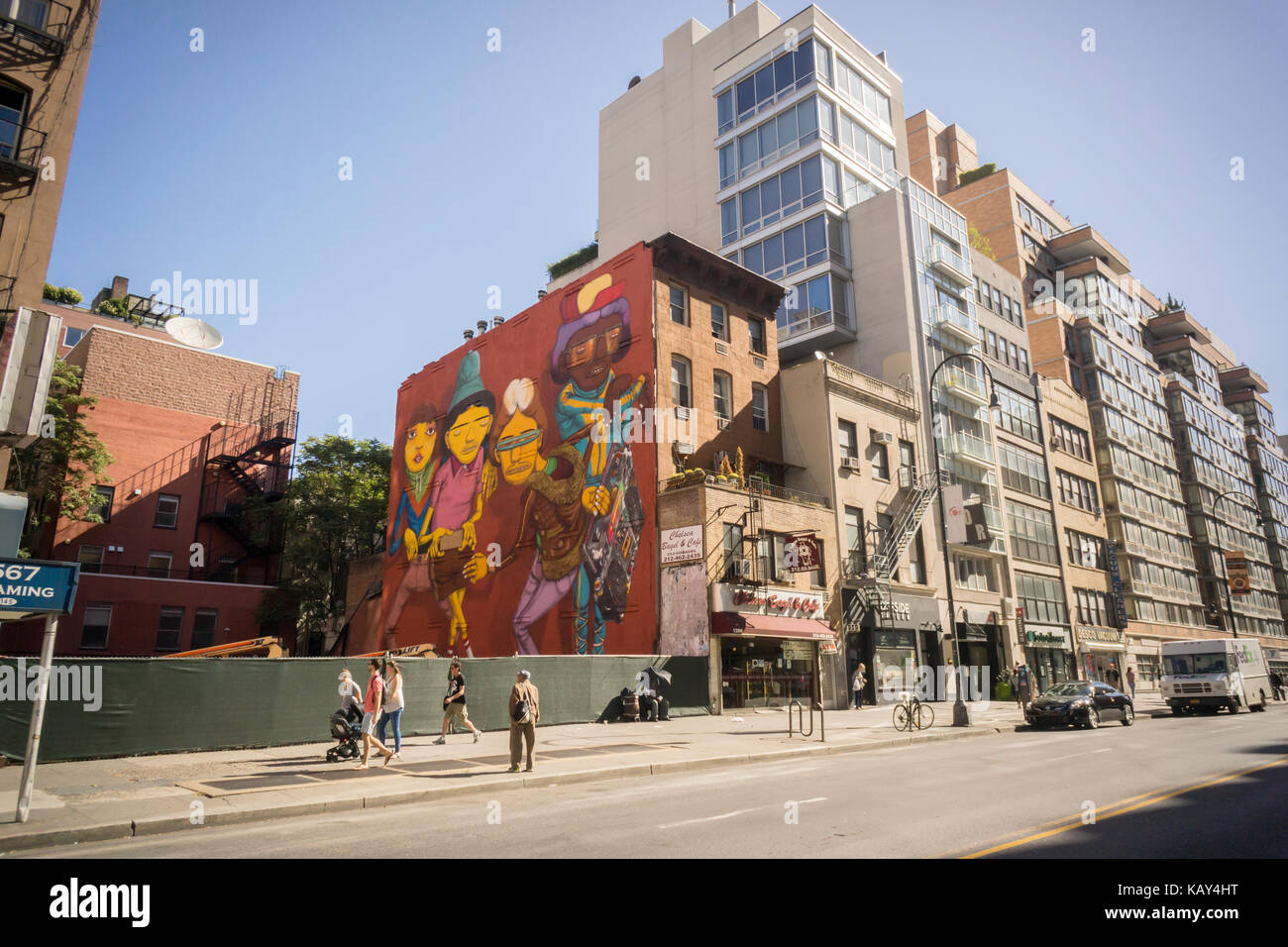 Ein Wandgemälde des brasilianischen Graffiti-Künstlers OS Gémeos, die Zwillinge in englischer Sprache, ziert die Seite eines Gebäudes vor dem angrenzenden Bau im New Yorker Stadtteil Chelsea, gesehen am Samstag, 23. September 2017. Die brasilianischen Brüder Otavio und Gustavo Pandolfo, die sich OS Gémeos nennen, schufen das Wandbild. (© Richard B. Levine) Stockfoto