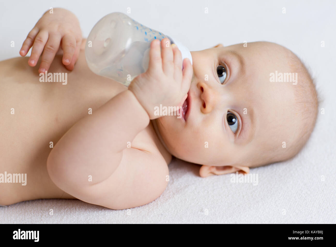Cute Baby mit Milchflasche auf weiße Decke Stockfoto