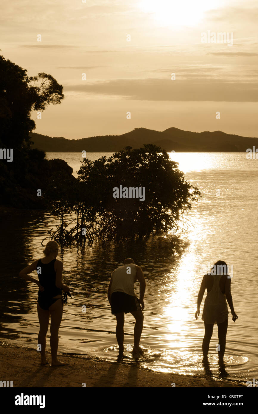 Philippinen Sonnenuntergang - westliche Touristen am Wasser bei Sonnenuntergang, South Malbinchilao Insel, Palawan, Philippinen, Asien Stockfoto