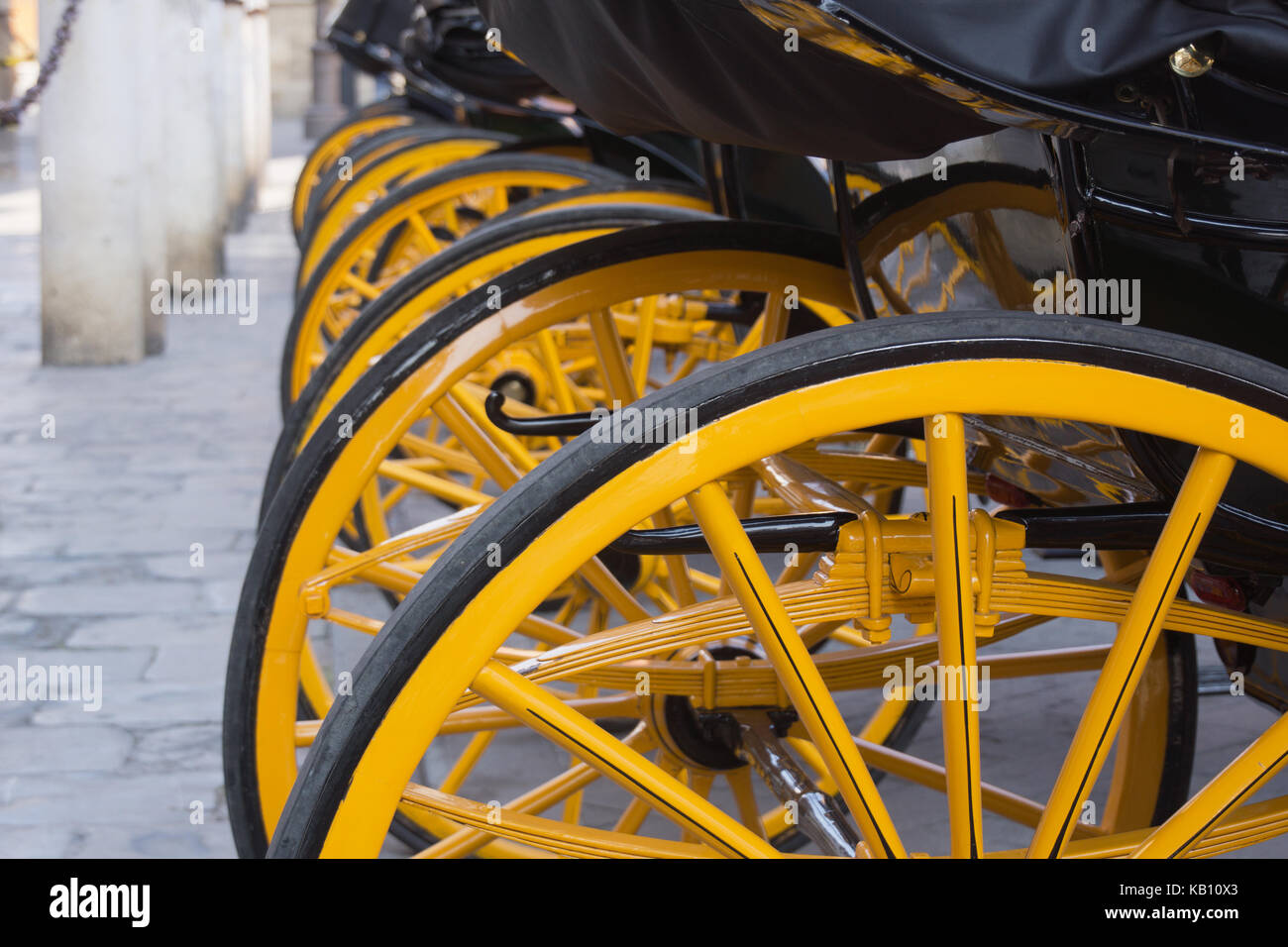 Gelbe Räder von Pferdekutschen in Sevilla Stockfoto