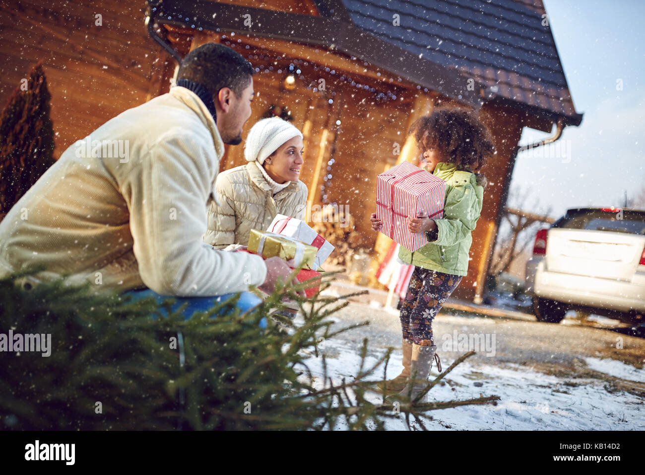 Afro-amerikanische kleine Mädchen hilft Eltern Kartons mit Geschenken im Mountain Haus zu bringen. Stockfoto