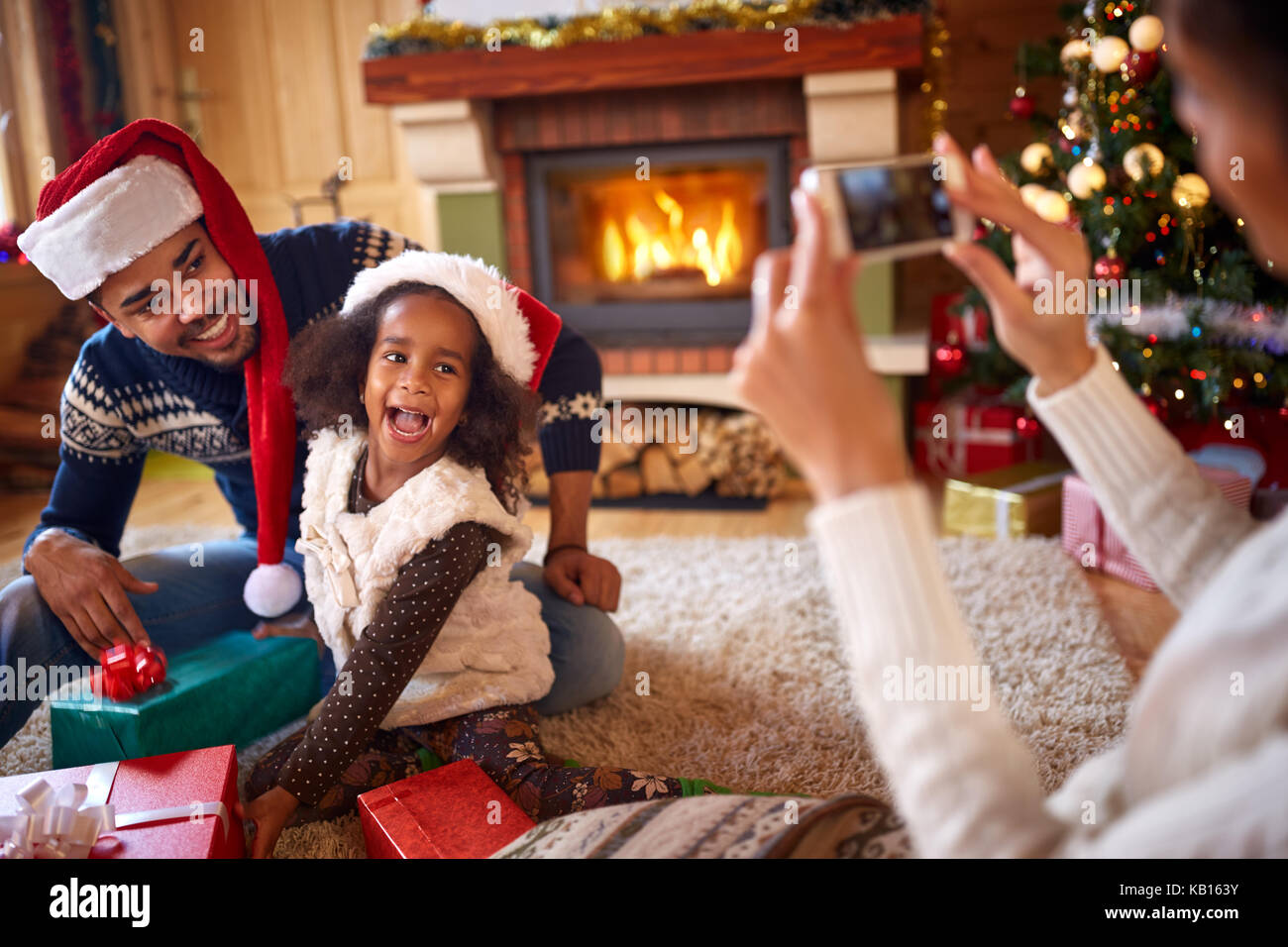 Glückliche kleine Mädchen mit Santa hat Ihre Mutter für Weihnachten Foto posiert Stockfoto