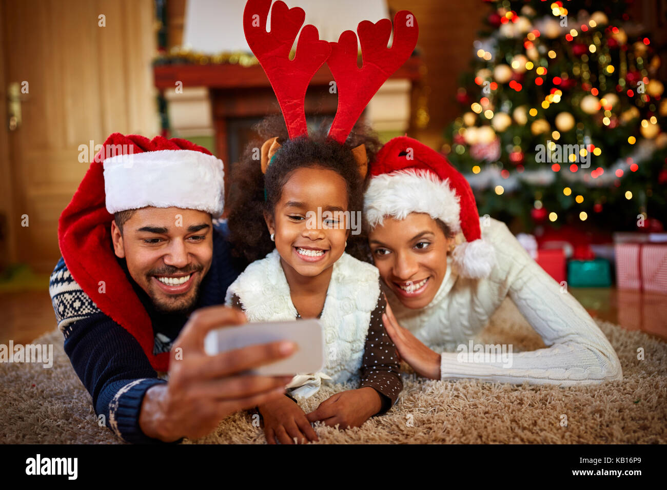 Süße kleine Mädchen mit ihren Eltern in Weihnachten Foto posiert Stockfoto