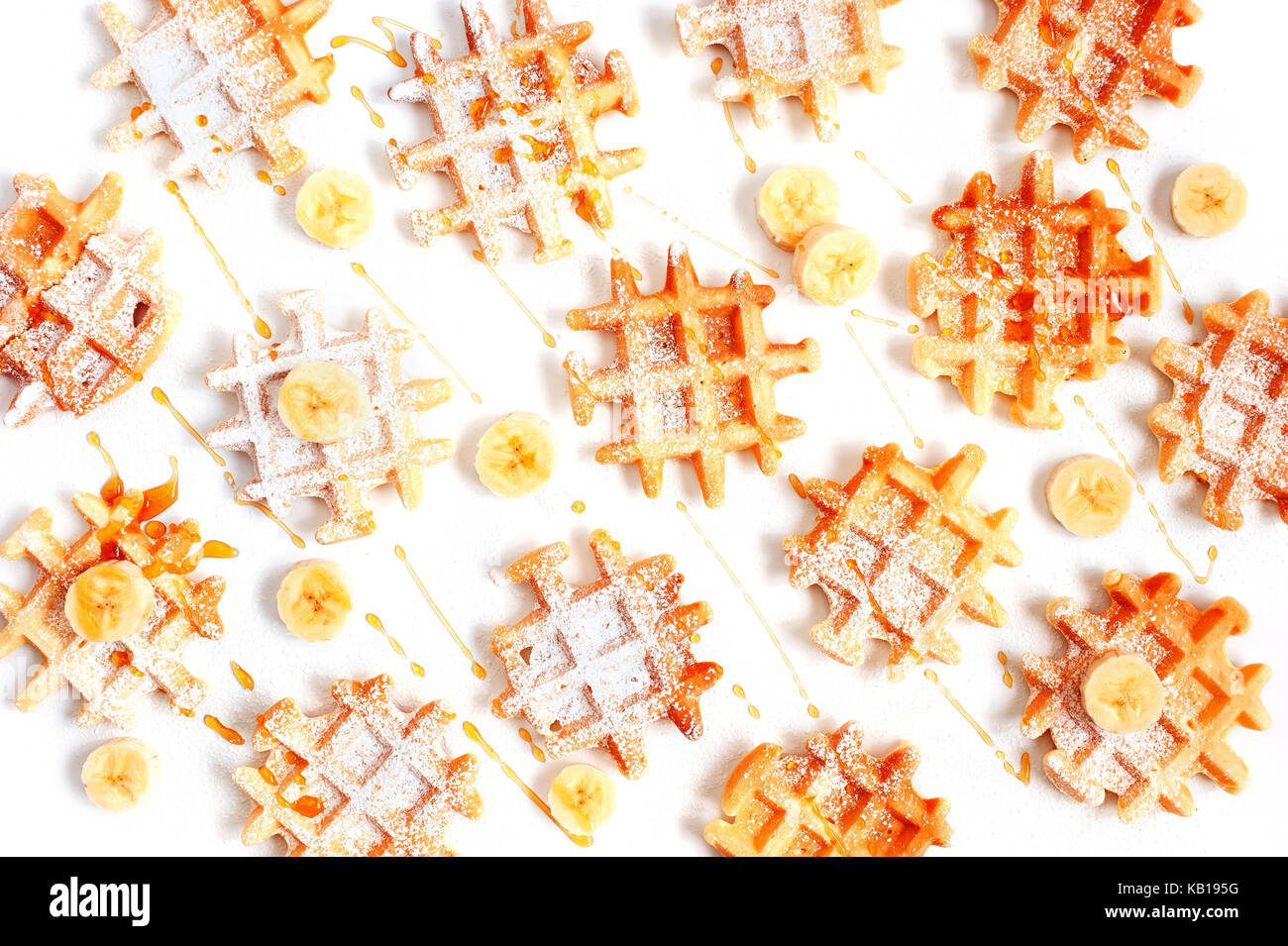 Viele kleine Waffeln mit Banane und Honig auf der weißen Tisch Stockfoto