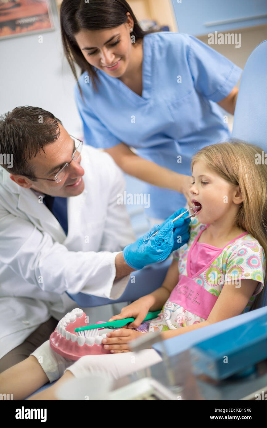 Zahnarzt views Zähne zu junges Mädchen mit Dental instruments Stockfoto