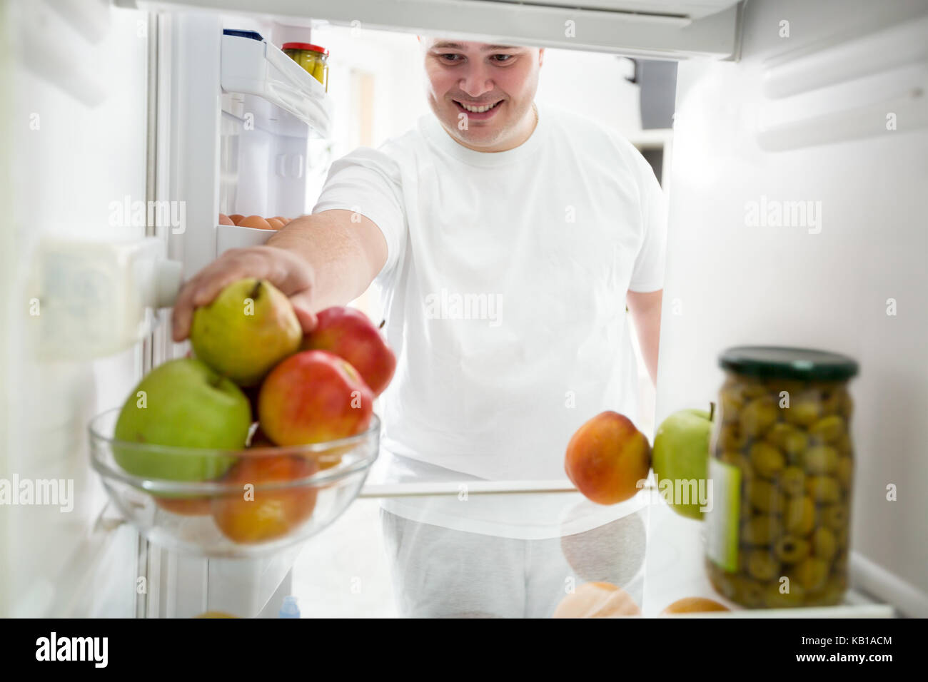 Fette Kerl auf einer Diät, Obst aus Kühlschrank Stockfoto