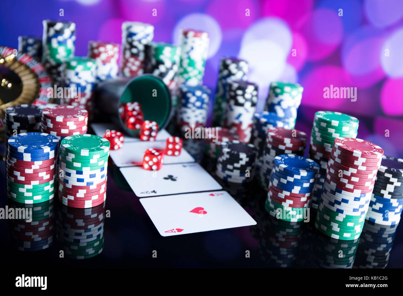 Casino Konzept. Roulette, Chips, Karten und Würfel auf bunten Bokeh. Stockfoto