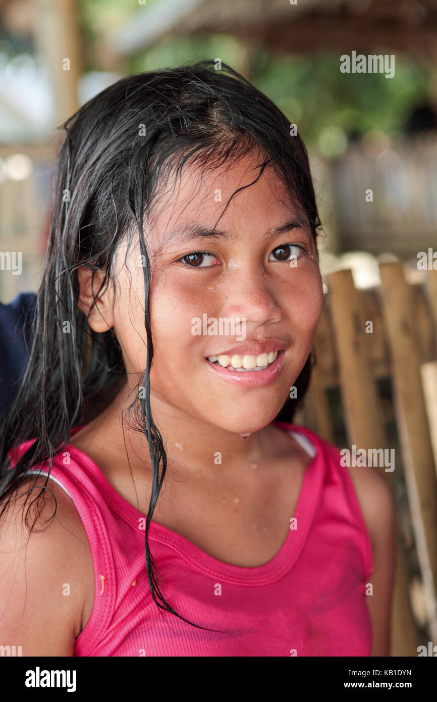 Porträt einer zwölf Jahre alten philippinischen Mädchen mit langen, schwarzen Haaren und einem hübschen Lächeln nass vom Schwimmen in Ormoc City, Leyte Island, Philippinen. Stockfoto