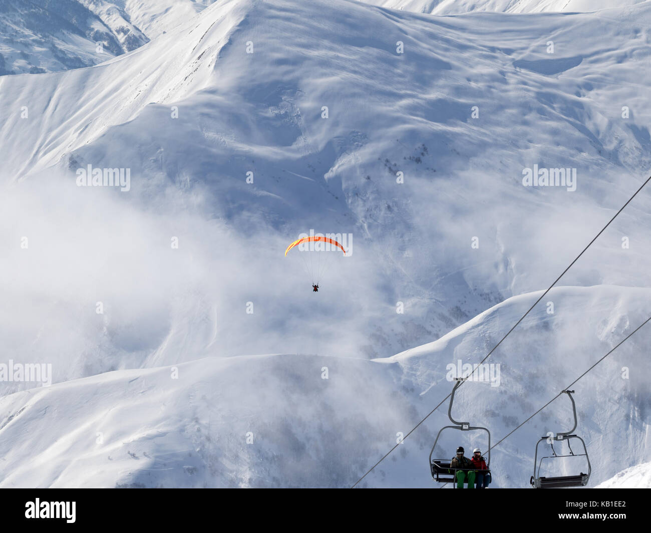 Sessellift und paraplane auf Ski Resort in kalten Wintertag. Schnee Kaukasus Berge im Nebel. Georgien, Region Gudauri. Stockfoto