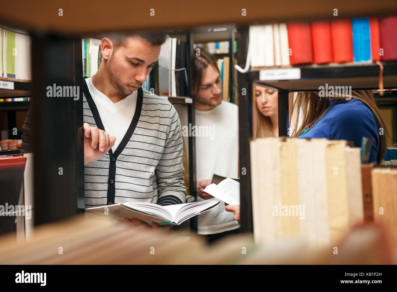 Studenten in der Bibliothek Auswahl Bücher Stockfoto