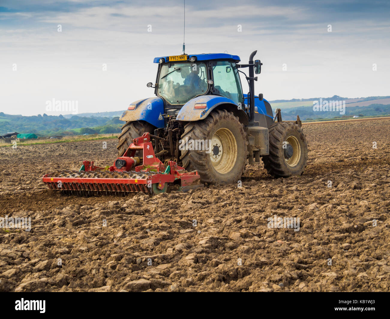 Ein Traktor und Harrow Vorbereitung ein Feld für die Aussaat von Wintergetreide in North Yorkshire England Großbritannien Stockfoto