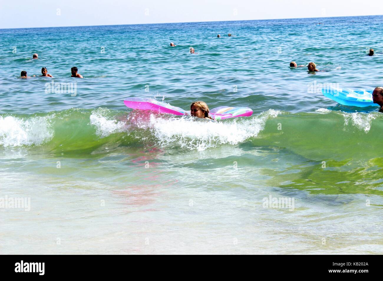 Juli, 2017 - Urlauber mit aufblasbaren Matratzen im Meer schwimmen im Cleopatra Beach (Alanya, Türkei). Stockfoto