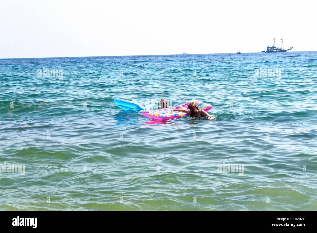 Juli, 2017 - Urlauber mit aufblasbaren Matratzen im Meer schwimmen im Cleopatra Beach (Alanya, Türkei). Stockfoto