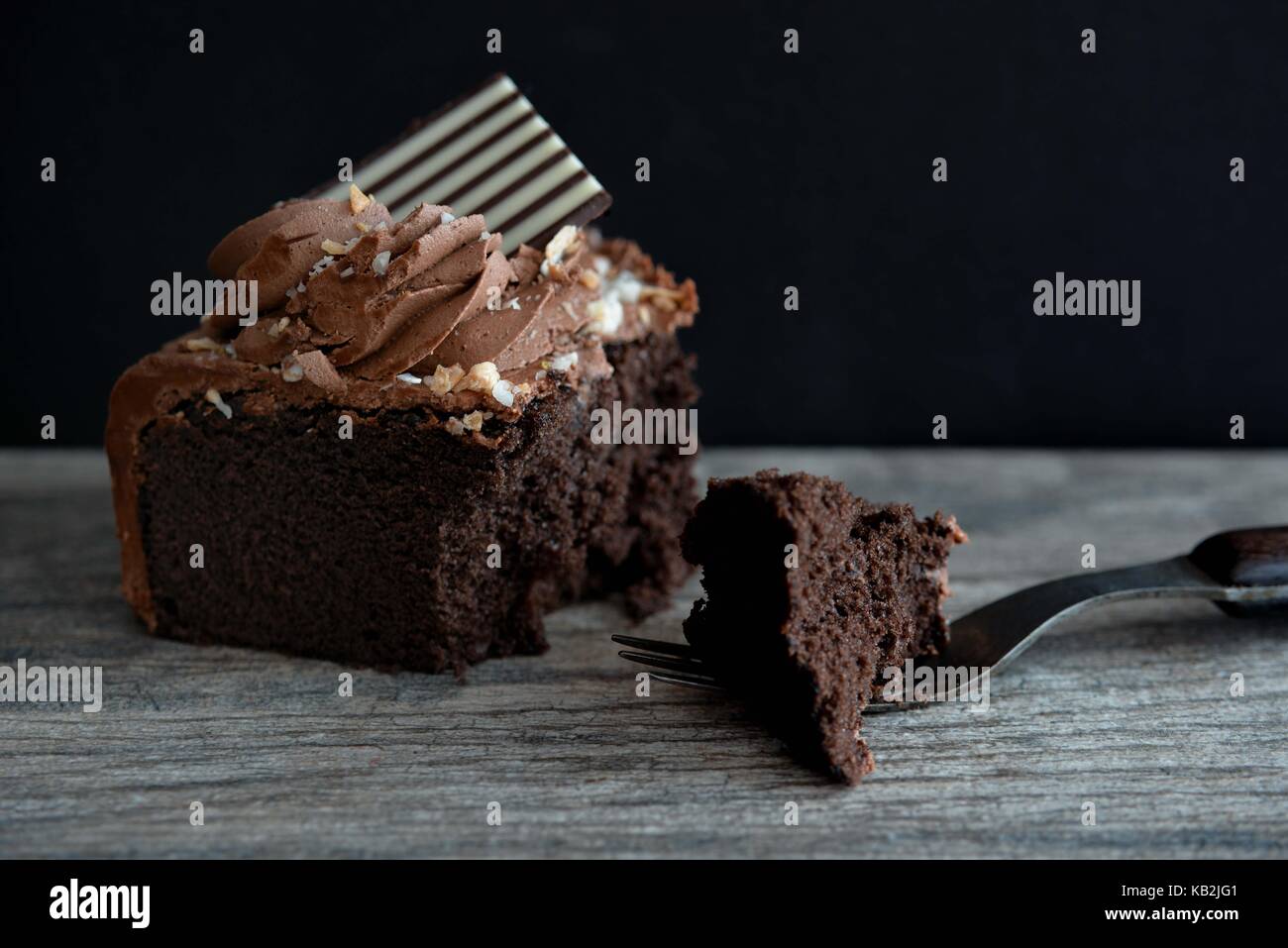 Dunkle Schokolade Kuchen mit Gabel auf dunklem Hintergrund Stockfoto