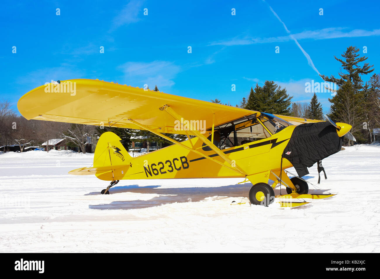Sport Cub S2 Flugzeug auf Skiern geparkt auf dem Schnee auf See angenehm in der Adirondack Park. Stockfoto