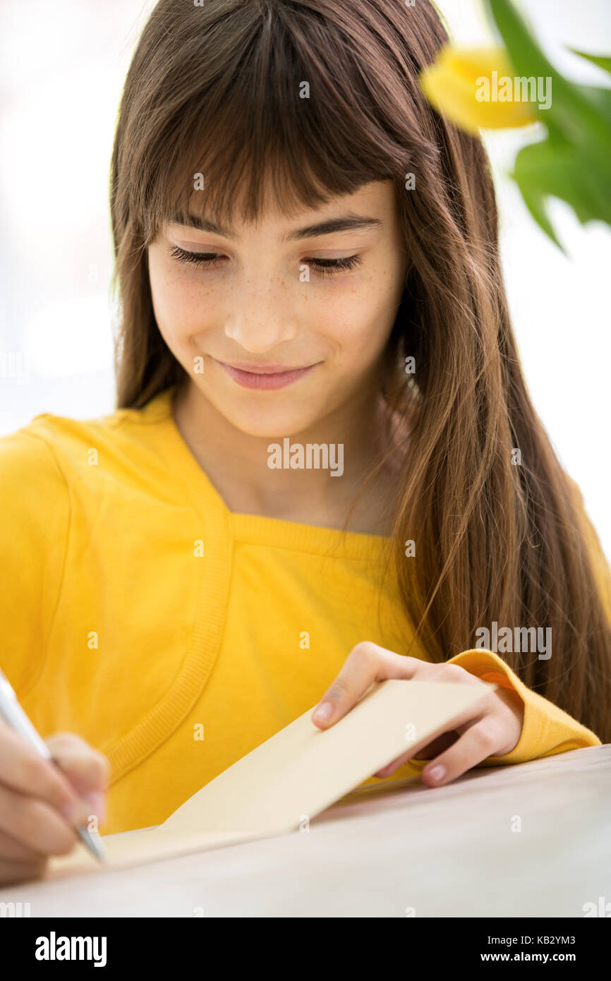 Schöne Mädchen schreibt Grußkarte Stockfoto