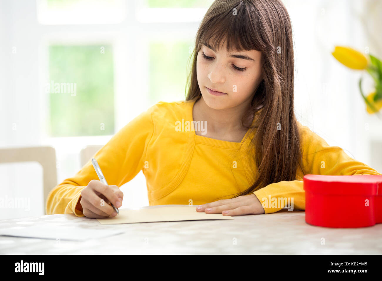 Schönen adorable Girl schreiben Grußkarte Stockfoto