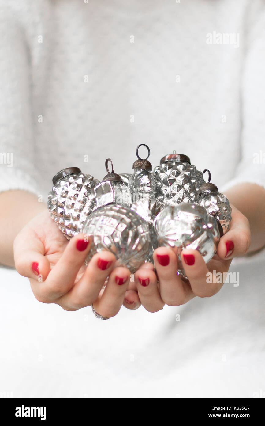 Frau mit Präsentation vintage silver Weihnachtsverzierungen beim Tragen der weißen, klassischen, eleganten, Porträt und Landschaft mit Raum für Kopie Stockfoto
