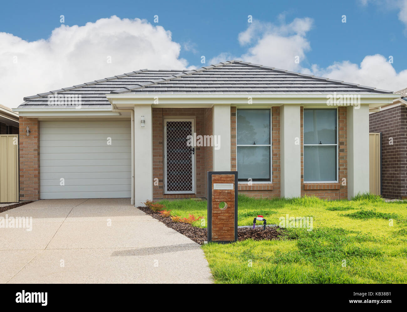 Typische Fassade eines neuen Ziegel moderne Suburban House gegen bewölkter Himmel Stockfoto