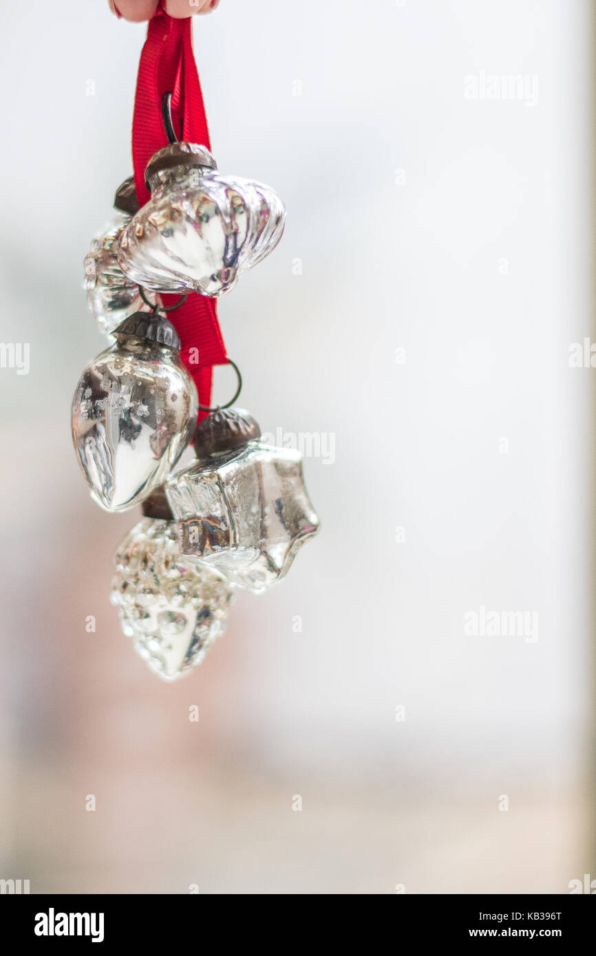Vintage silber Weihnachten Winter Urlaub Ornamente auf roten Bändern ruhig und friedlich in einem Fenster, Hochformat Zimmer für Kopie Stockfoto