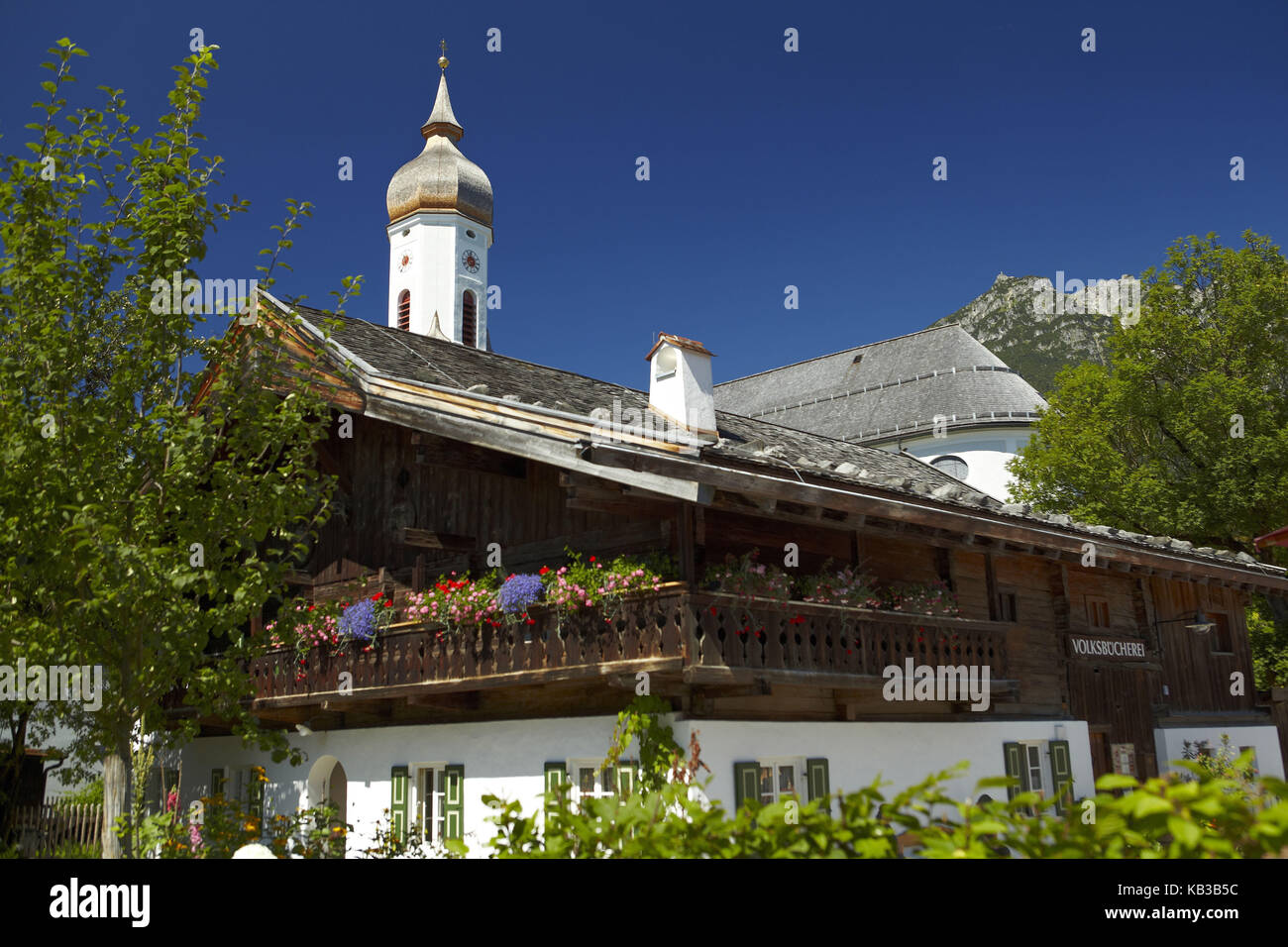 Deutschland, Bayern, Werdenfelser Land (Region), Garmisch-Partenkirchen, Polznkasparhaus mit St. Martin Kirche, Sommer, Bauerngärten, Stockfoto