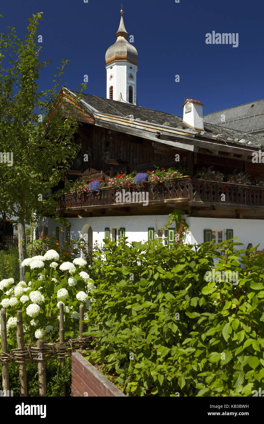 Deutschland, Bayern, Werdenfelser Land (Region), Garmisch-Partenkirchen, Polznkasparhaus mit St. Martin Kirche, Sommer, Bauerngärten, Stockfoto