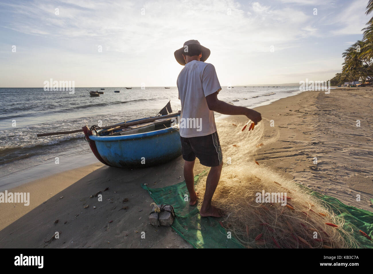 Vietnam, Mui Ne, Mui Ne Strand, Fischer und typische 'Coracle' Fischerboot am Strand, Stockfoto