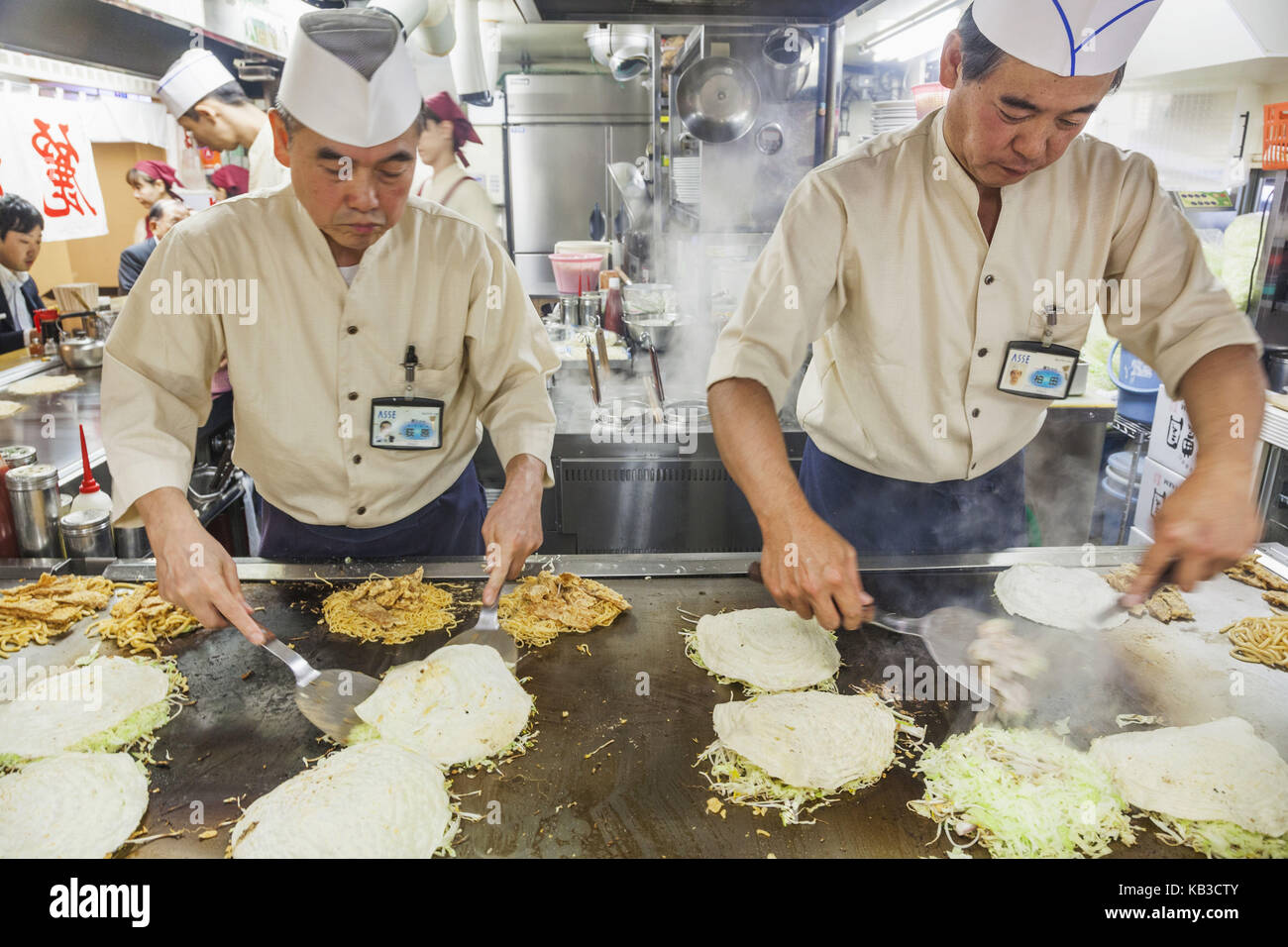 Japan, Kyushu, Hiroshima, Restaurant, Köche bei der Zubereitung von okonomiyaki, Stockfoto