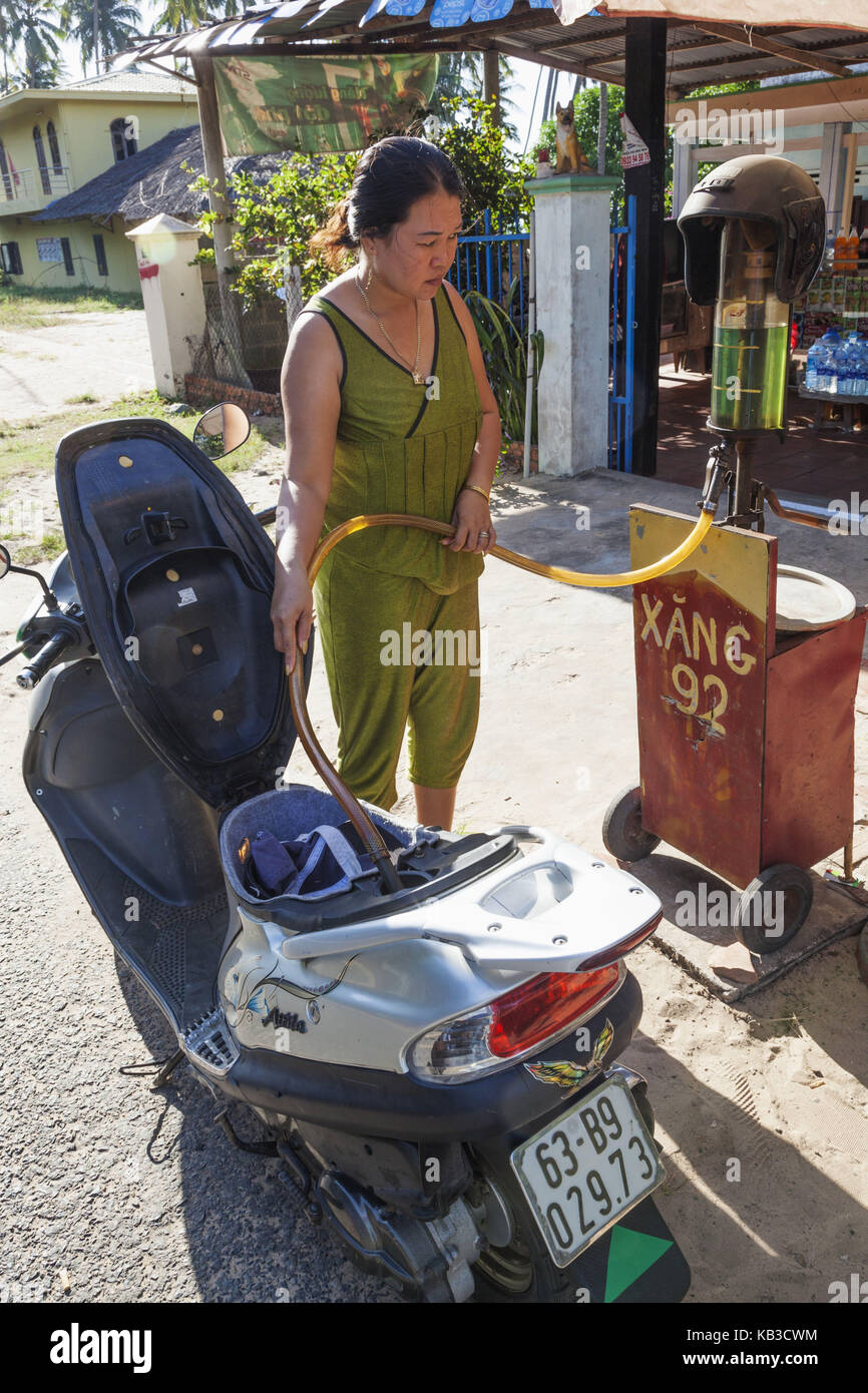 Vietnam, Mui Ne, Mui Ne Strand, Frau füllt Benzin in den Tank Ihres Motorroller, Stockfoto
