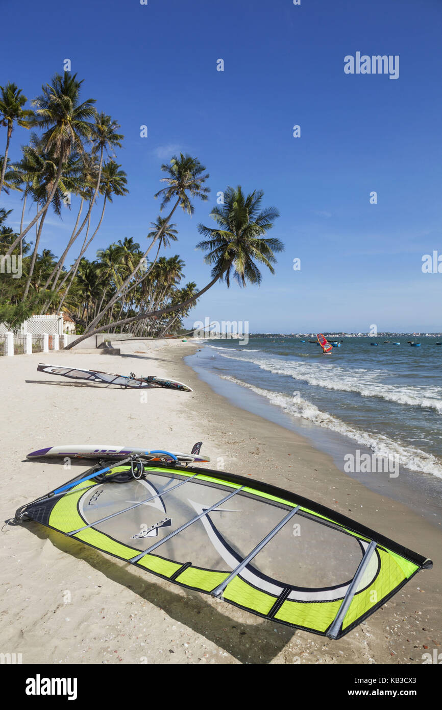 Vietnam, Mui Ne, Mui Ne Strand, Windsurfen, Surfbrett und Segel auf dem Palm Beach, Stockfoto