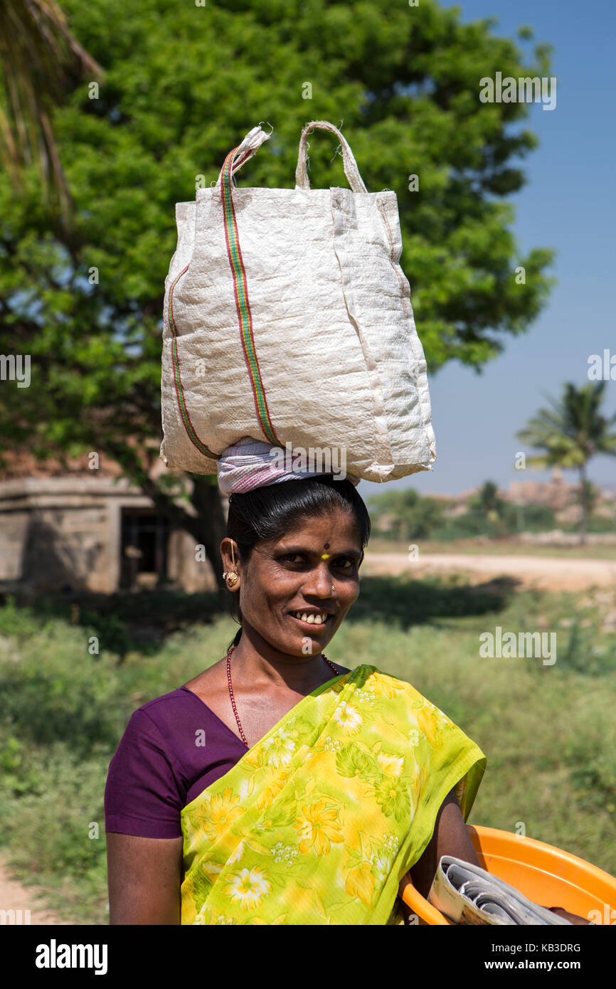 Indien, Karnataka, hampi, lokale Frau trägt Last auf dem Kopf Stockfoto