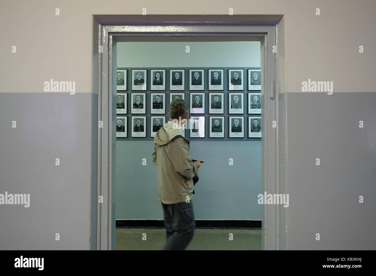 Touristen, durch Porträts von Gefangenen auf dem zweiten Weltkrieg NS-Konzentrationslager Auschwitz Museum, Polen Stockfoto