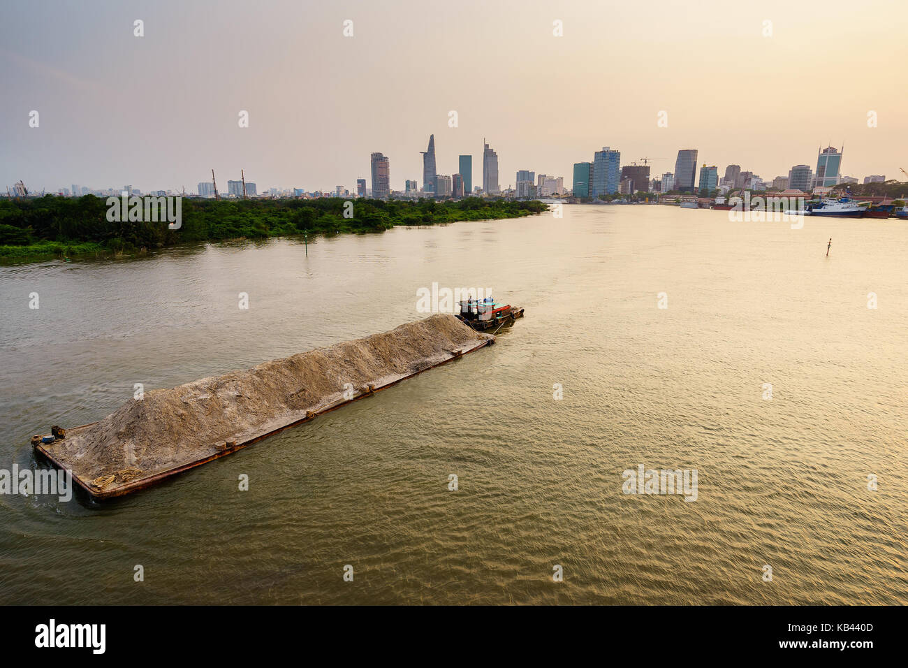 Barge auf Saigon River im Sonnenuntergang, Ho Chi Minh City, Vietnam. Ho Chi Minh City (Saigon) ist die größte Stadt und das wirtschaftliche Zentrum in Vietnam. Stockfoto