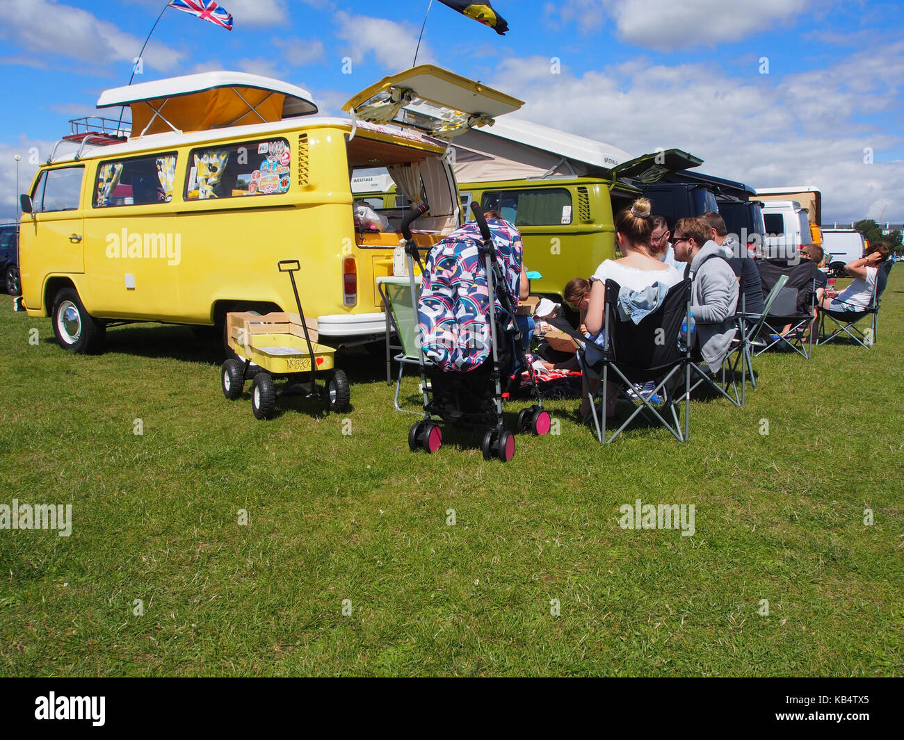 Menschen auf Camping Stühle mit einem VW Wohnmobil treffen Stockfoto