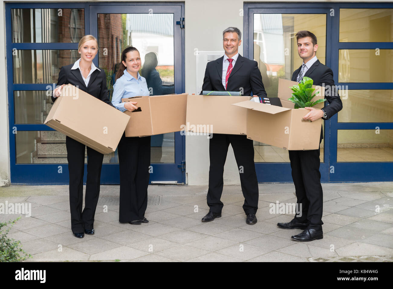 Happy Gruppe von Geschäftsleuten mit Karton Umzug in neues Büro Stockfoto