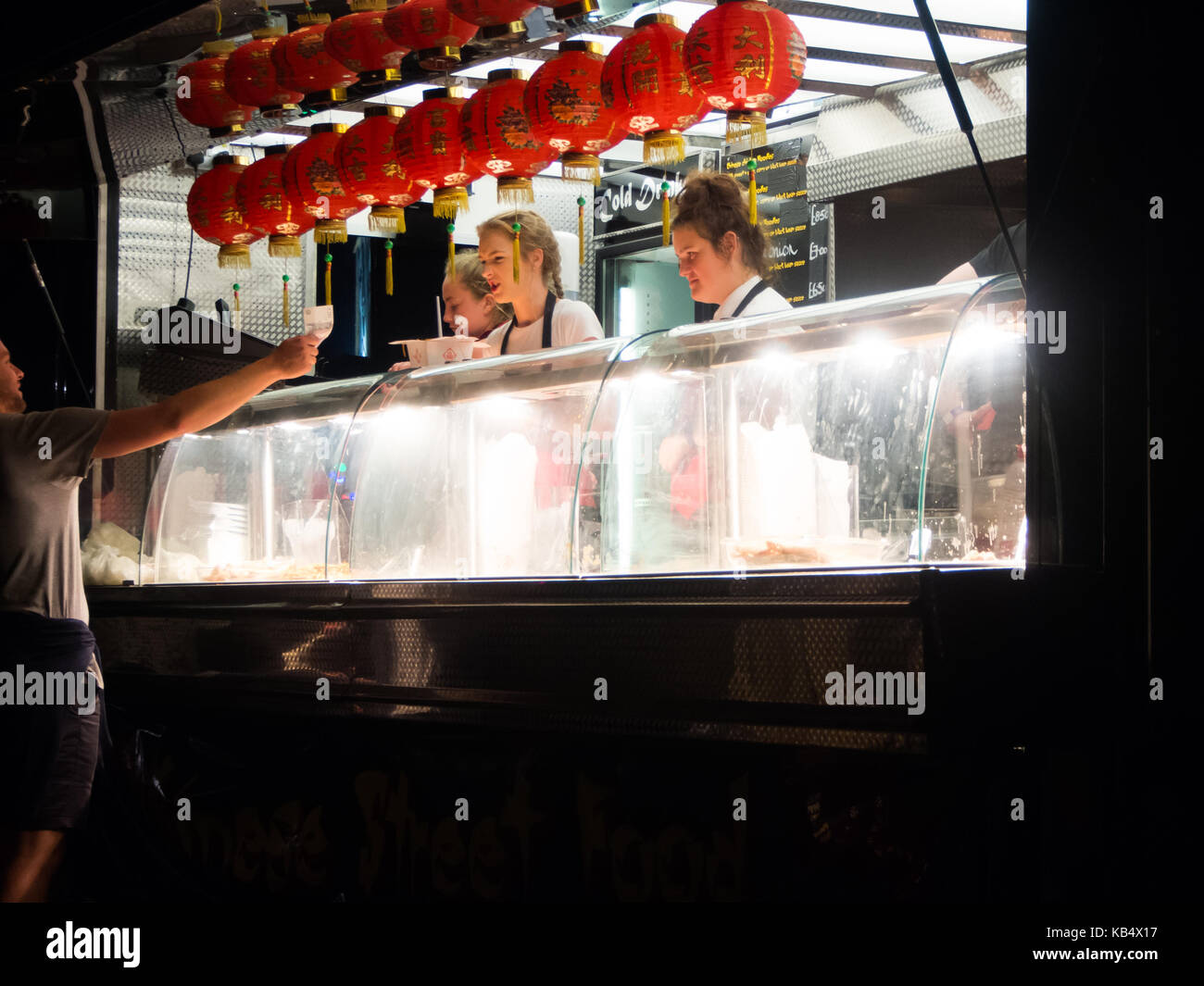 Ein catering Truck in der Nacht mit jungen Damen servince Kunden Stockfoto