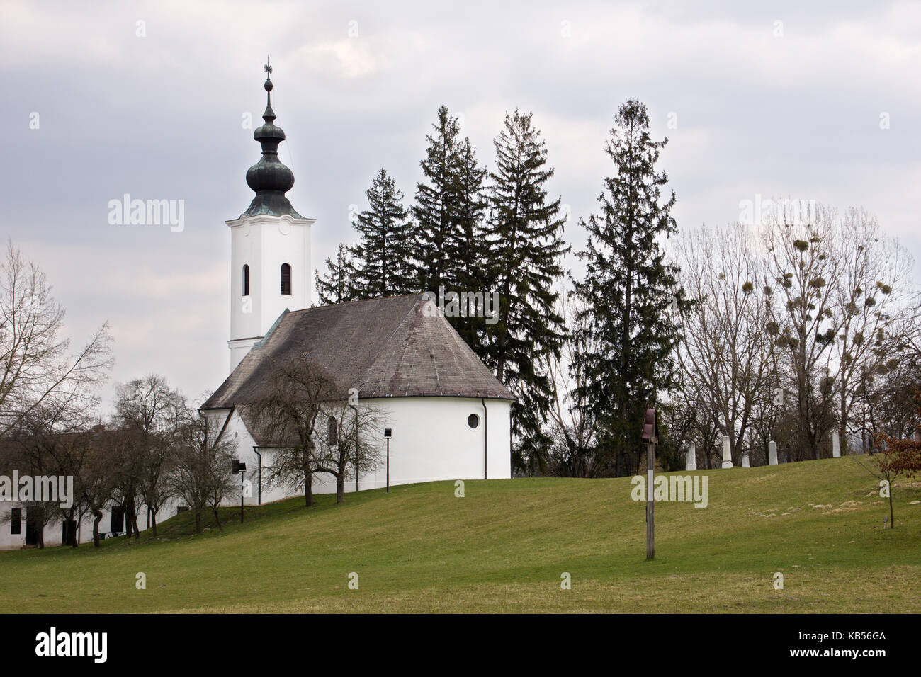 Schöne kleine ungarische Kirche in Szenna mit einem bewölkten Himmel Stockfoto
