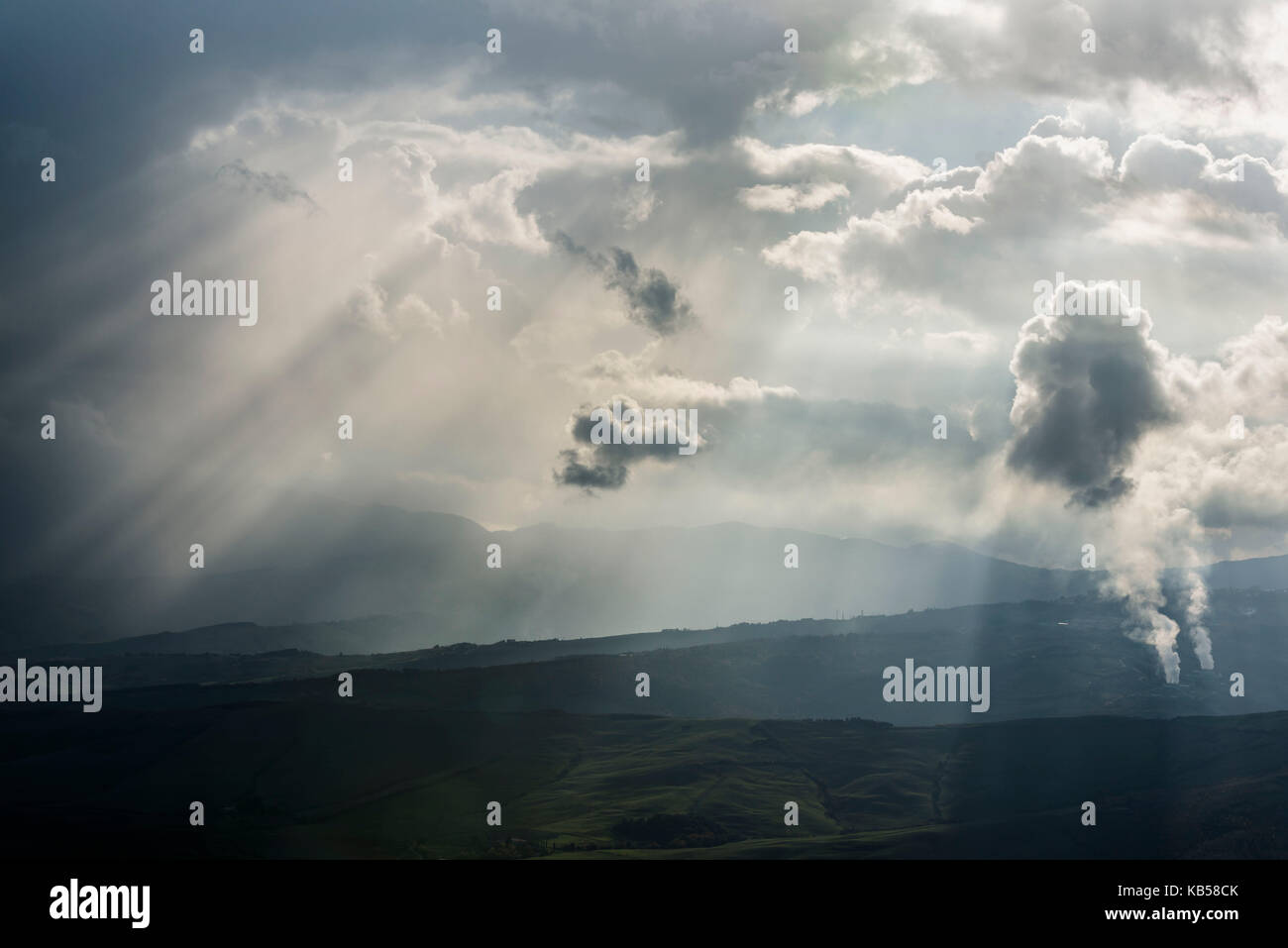 Eine futuristische Ansicht der Dampf stieg von geothermischen Kraftwerks in radicofani Region Italiens und Sonnenstrahlen auffällig durch dunkle Wolken Stockfoto