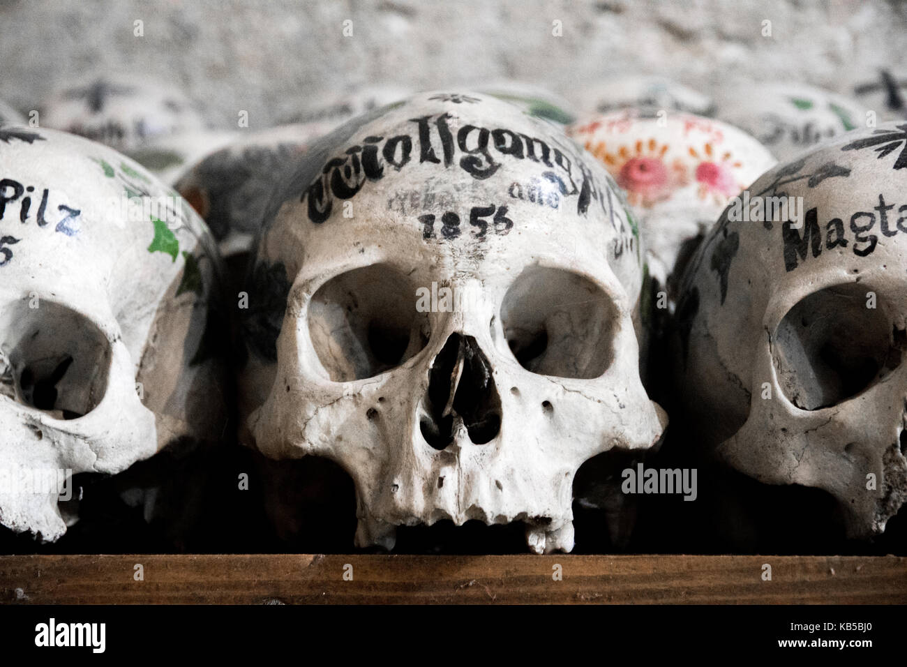Schadel Mit Namen Bunten Blumen Und Kreuze In Der Leichenhalle Oder Beinhaus Hallstatt Osterreich Lackiert Stockfotografie Alamy