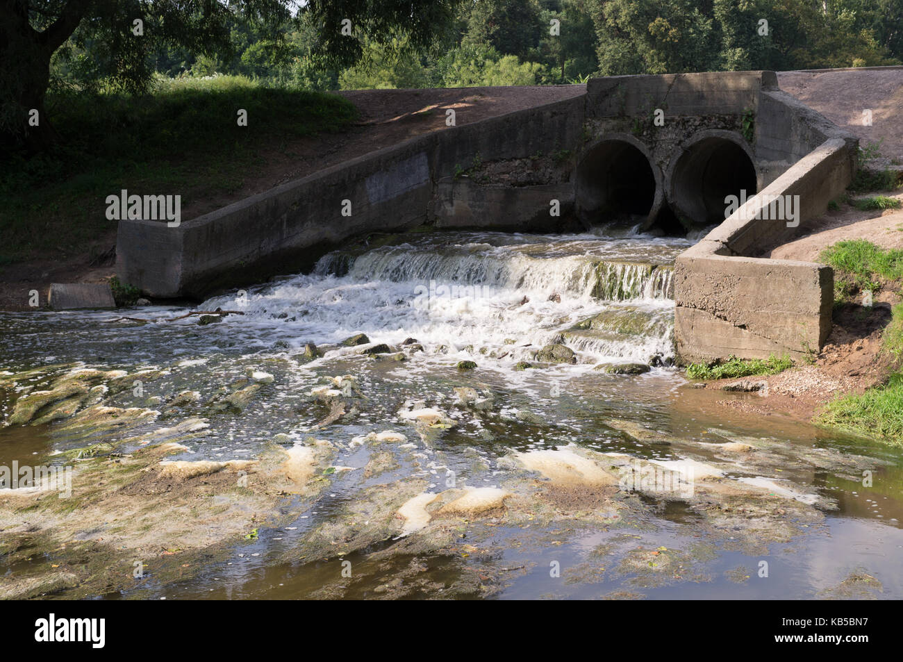 Stein Teich Entwässerung mit kleinem Wasserfall. Hintergrund, Natur. Stockfoto