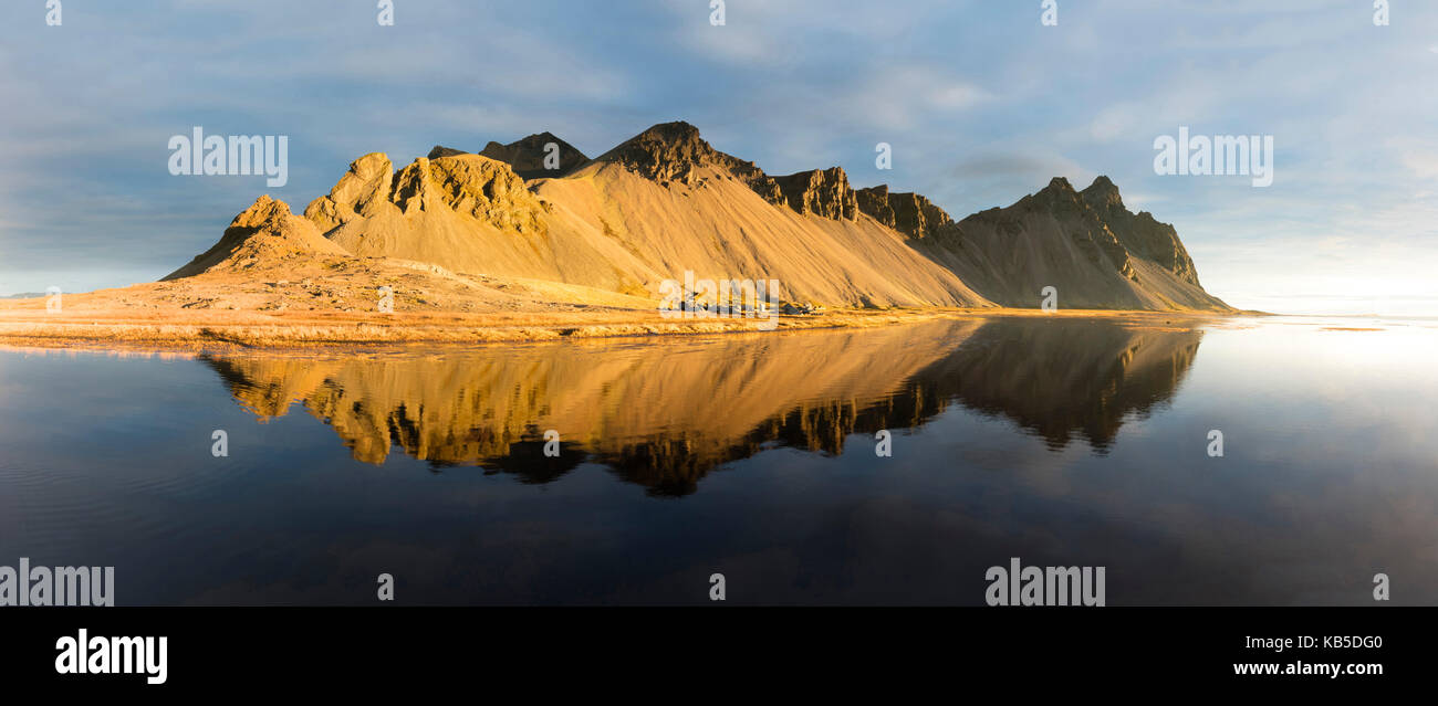 Panoramablick auf Berge von Vestrahorn und perfekte Reflektion im flachen Wasser, kurz nach Sonnenaufgang, Stokksnes, South Island Stockfoto