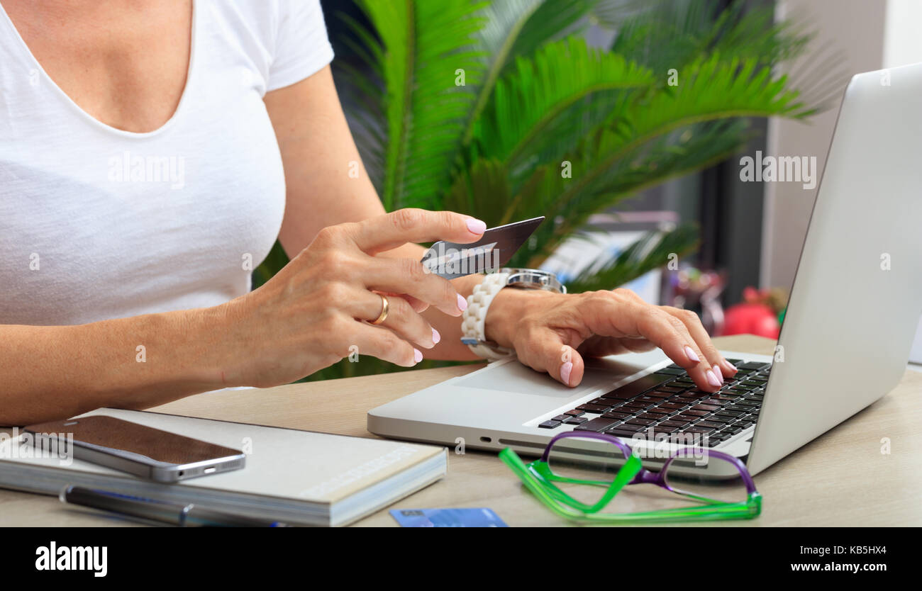 Online shopping Konzept. Frau mit einer Kreditkarte in einem Büro Hintergrund Stockfoto