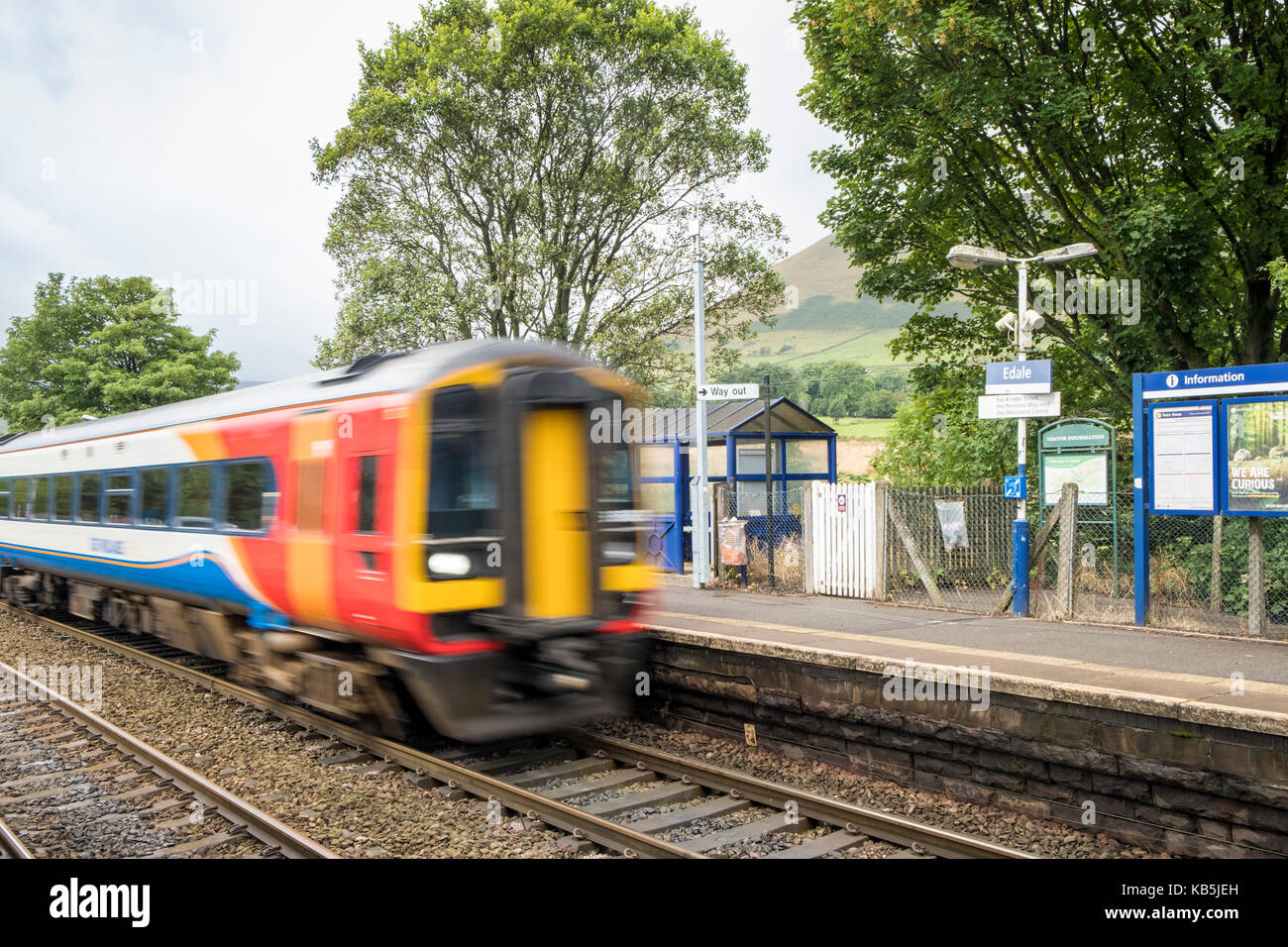 Eine schnelle East Midlands Trains Zug, der durch die kleinen ländlichen Bahnhof Alfreton, Derbyshire, Peak District, England, Großbritannien Stockfoto