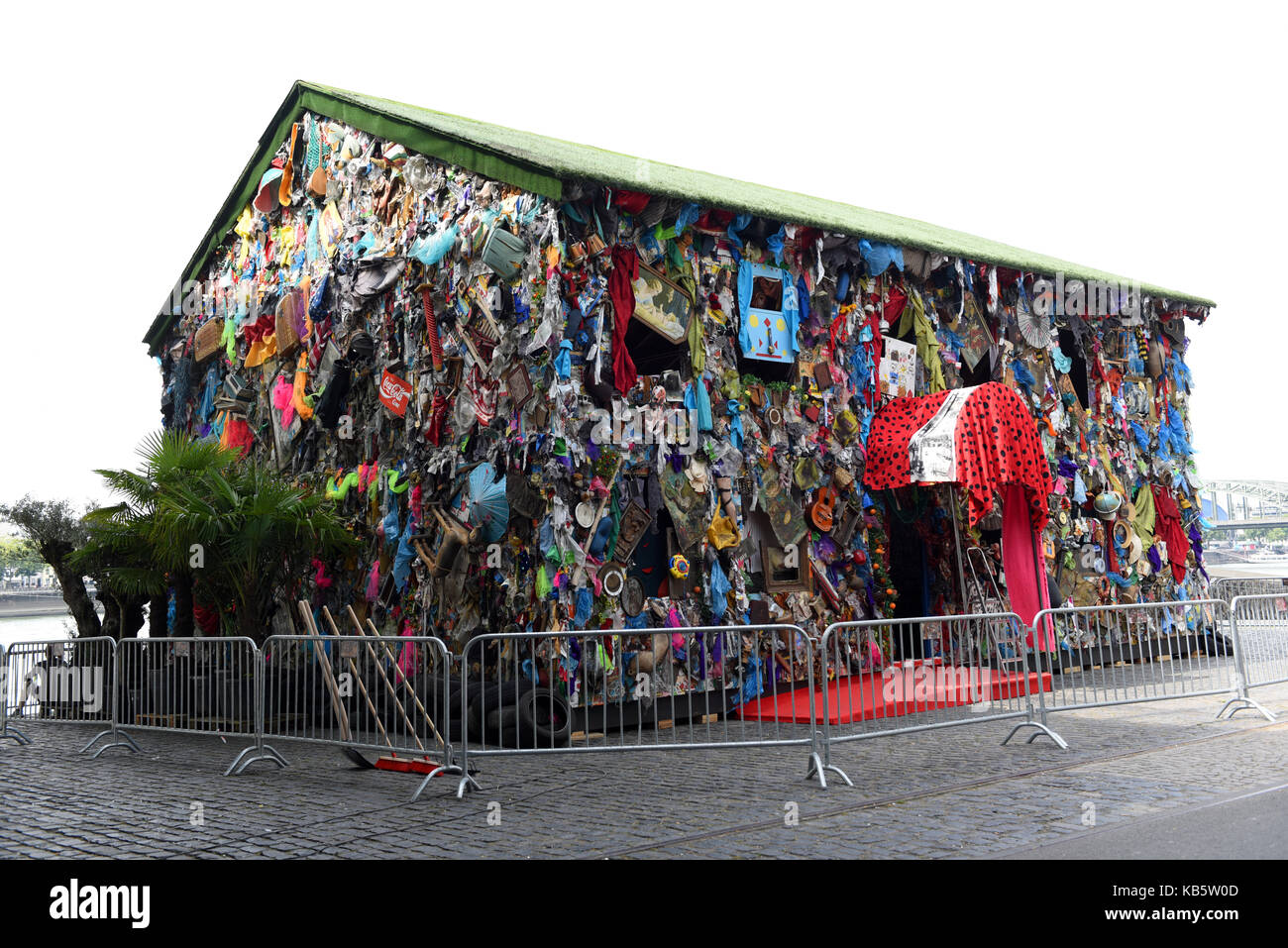 Köln, Deutschland. 30 Aug, 2017. Exklusiv: Der Papierkorb Haus 'Speichern der Welt Hotel", ein Projekt des Künstlers HA Schult, kann am Ufer des Rheins in der Nähe des Deutzer-Rhein Brücke in Köln, Deutschland, 30. August 2017 zu sehen. Die Kunst Projekt besteht aus einem Holz- Haus, das im Müll bedeckt ist, und auch mit "Papierkorb" eingerichtet. Den Papierkorb Haus wird vom 31. August bis 17. September 2017. Credit: Horst Ossinger/dpa/Alamy leben Nachrichten Stockfoto