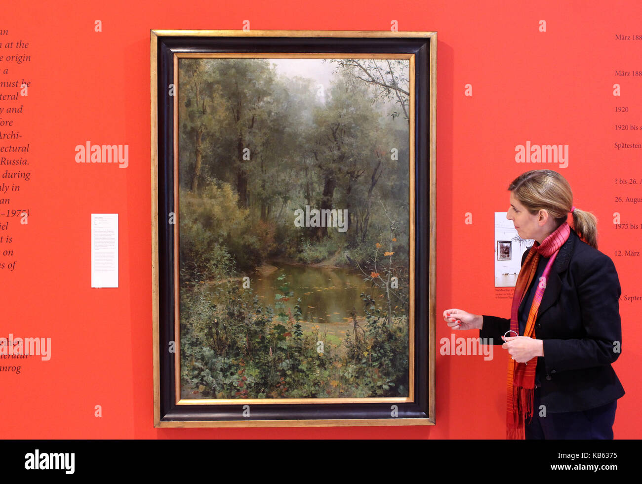 Kiel, Deutschland. 26 Sep, 2017. Museum Direktor Anette Huesch steht neben dem gestohlenen Gemälde "waldweiher" (Lit. "Wald Teich") durch russische Maler Vasily Polenov in der Kunsthalle (Kunsthalle) in Kiel, Deutschland, 26. September 2017. Das Gemälde aus dem Jahre 1881, die von deutschen Truppen im Jahre 1943 gestohlen wurde und zusammen mit anderen Sammlern Objekte aus dem örtlichen Museum im Süden der russischen Stadt Taganrog an einen unbekannten Ort, wieder in das Staatliche Museum für Literatur und Architekturgeschichte in Taganrog gegeben werden. Credit: Matthias Hoenig/dpa/Alamy leben Nachrichten Stockfoto